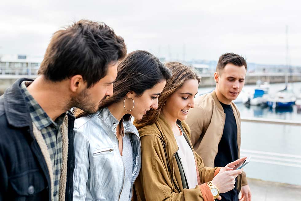 A group of people looking at the phone for the Teamland Capture the Flag team building activity